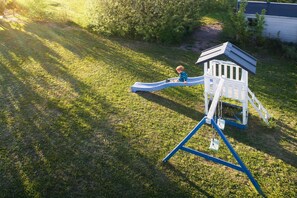 A playground with a slide and a climbing structure.