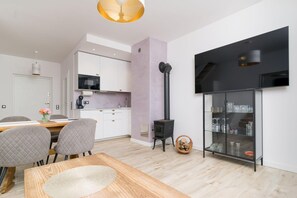 A modern kitchen with white cabinets, a microwave, and a black stove.
