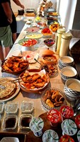 Una mesa de buffet con diversos alimentos y salsas.