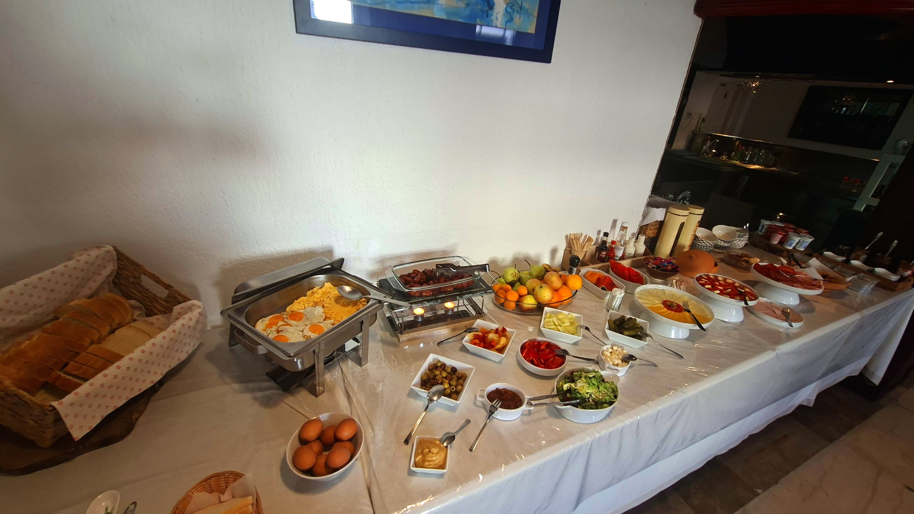A buffet table with various food items and condiments.