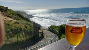 A glass of Stella Artois beer with a coastal view.