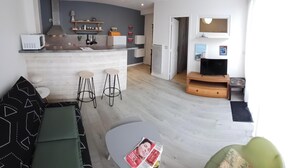 A modern living room with a sofa, a coffee table, and a TV.