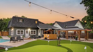 A residential property with a backyard featuring a pool, patio furniture, and a wooden deck.