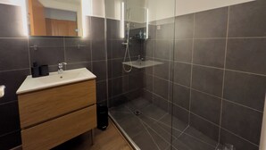 Een douche, handdoeken, zeep, toiletpapier