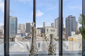 A view of a cityscape through a window with two metallic objects on the sill. - X Lounge VI-Premium Corner Residence (Miami)