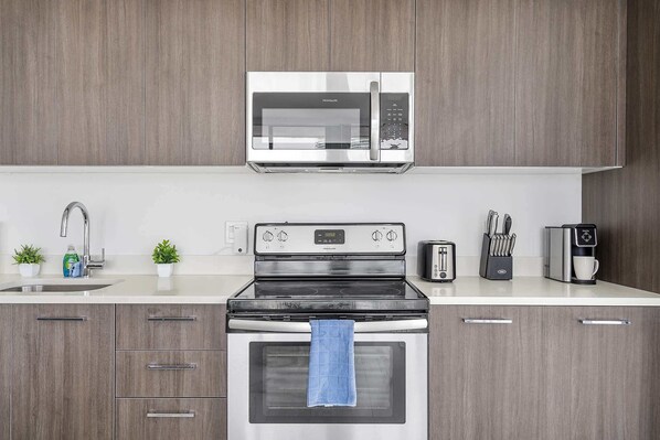 A modern kitchen with a stainless steel microwave, a built-in oven, a toaster, and a coffee maker. - X Lounge VI-Premium Corner Residence (Miami)