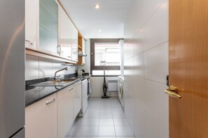 A narrow kitchen with a dishwasher, sink, and a window with a view of the outside. - Experience the essence of Madrid from this bright, 90 m² apartment in the heart of Chamartín, located at the iconic Paseo de la Castellana 118. Its location is unbeatable: directly across from El Corte Inglés department store in Nuevos Ministerios (MADRID)