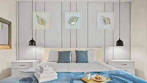 Een moderne slaapkamer met een bed, nachtkastjes, een blauwe plaid en kunst aan de muur.