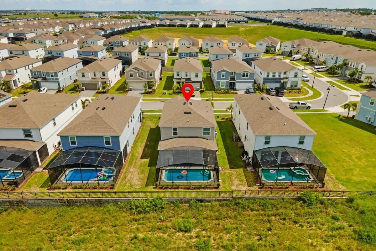 Zona residencial con casas, una piscina y un marcador rojo indicando la ubicación.