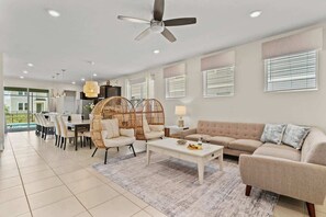 A modern living room with a sofa, coffee table, and wicker chairs. - Sunshine Escape – Windsor Island Resort (WI 2220) (Davenport)