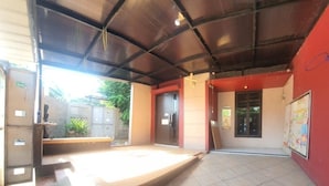 Un espace intérieur doté d’un sol carrelé, d’une scène et d’un mur rouge orné d’une affiche.