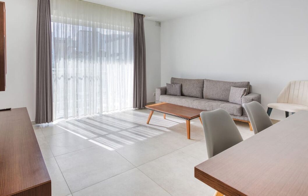 Una sala de estar moderna con un sofá, una mesa de centro y una mesa de comedor.
