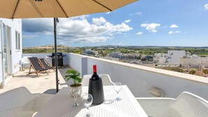 Ein Balkon mit einem Tisch für zwei Personen, einer Weinflasche und zwei Gläsern.