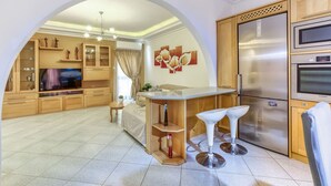 A modern kitchen with a central island, built-in appliances, and a dining area with bar stools.