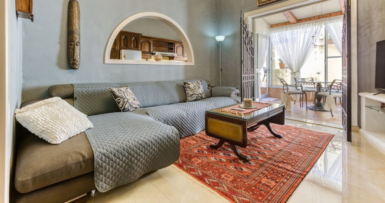A living room with a sofa, a coffee table, and a patterned rug.