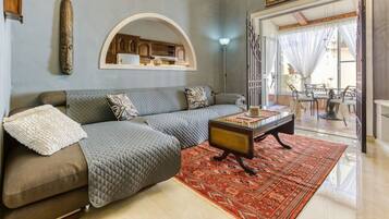 A living room with a sofa, a coffee table, and a patterned rug.