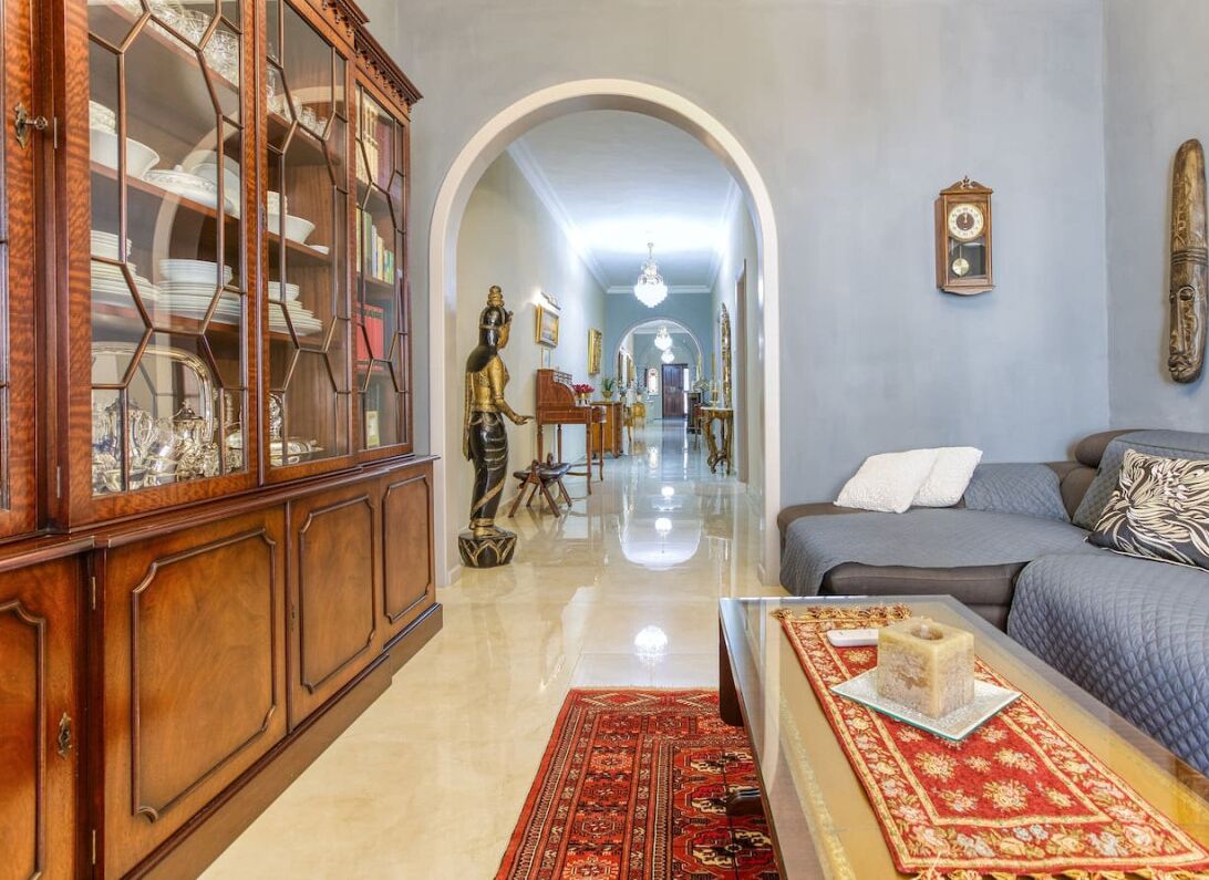 A living room with a sofa, a coffee table, a cabinet, and a rug.