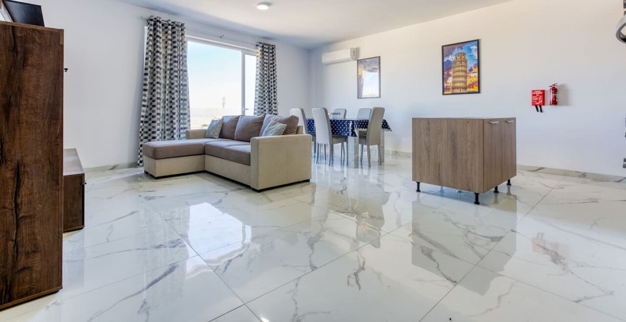 Een moderne woonkamer met een modulaire bank, een houten kast en een eethoek met tafel en stoelen.