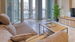 A modern living room with a sofa, coffee table, and a TV on a wooden cabinet.