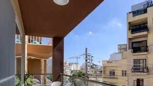 A balcony with two chairs, a table, and potted plants. - Beautiful 3BR home in charming Marsascala w/WIFI (Wied il-Għajn)