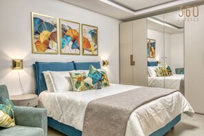Ein Schlafzimmer mit einem Bett, Nachttischen, einem Sessel und einem großen Spiegel.