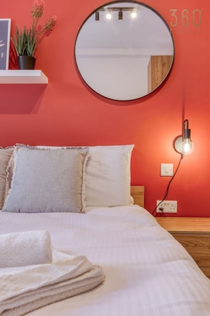 2 habitaciones, escritorio y tabla de planchar con plancha