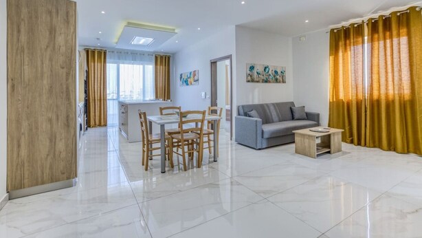 A modern living room with a dining area, a grey sofa, and a wooden coffee table.