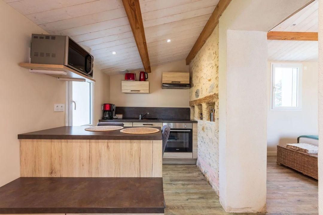 A compact kitchen with a central island, built-in oven, and microwave.