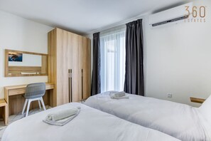 2 habitaciones, escritorio y tabla de planchar con plancha