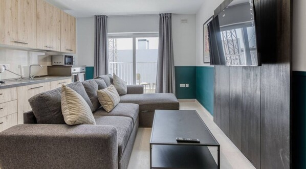 A modern living room with a sofa set, a coffee table, and a TV.