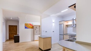 Una cucina moderna con mobili in legno, forno incassato e lavandino in acciaio inossidabile.