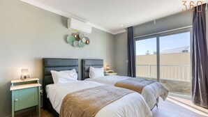 A bedroom with two beds, a balcony, and a view of the outside. - Spacious 3BR home with private Balconies in Mosta (Il-Mosta)