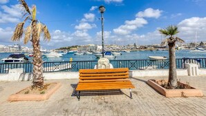 A waterfront bench with a view of a marina and boats. - Lovely, Spacious 4BR Apt in the heart of Gzira (Il-Gżira)