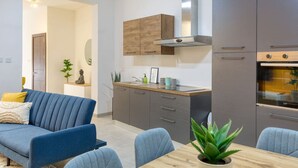 A modern kitchen with grey cabinets, a wooden countertop, and a built-in oven. - Lovely, Spacious 4BR Apt in the heart of Gzira (Il-Gżira)