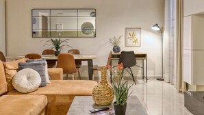 Una sala de estar moderna con un sofá, una mesa de centro y un comedor con sillas y una mesa.