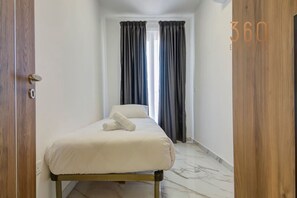 2 habitaciones, escritorio y tabla de planchar con plancha