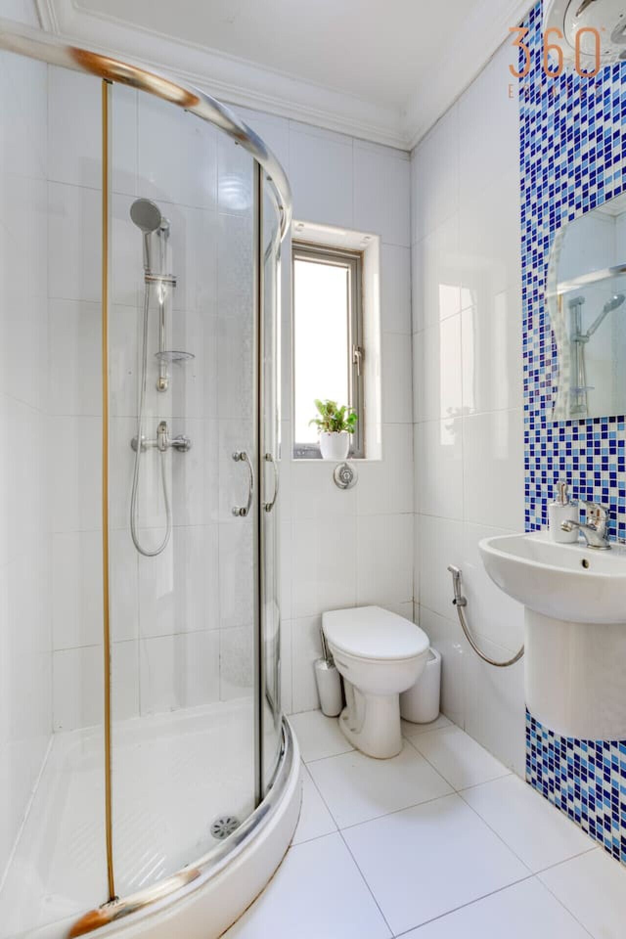 Ein modernes Badezimmer mit Duschkabine, Toilette und Waschbecken.