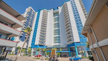 A multi-story hotel with a modern design, featuring balconies and a central atrium.