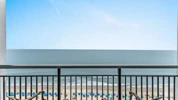 A balcony with a view of a beach and ocean.