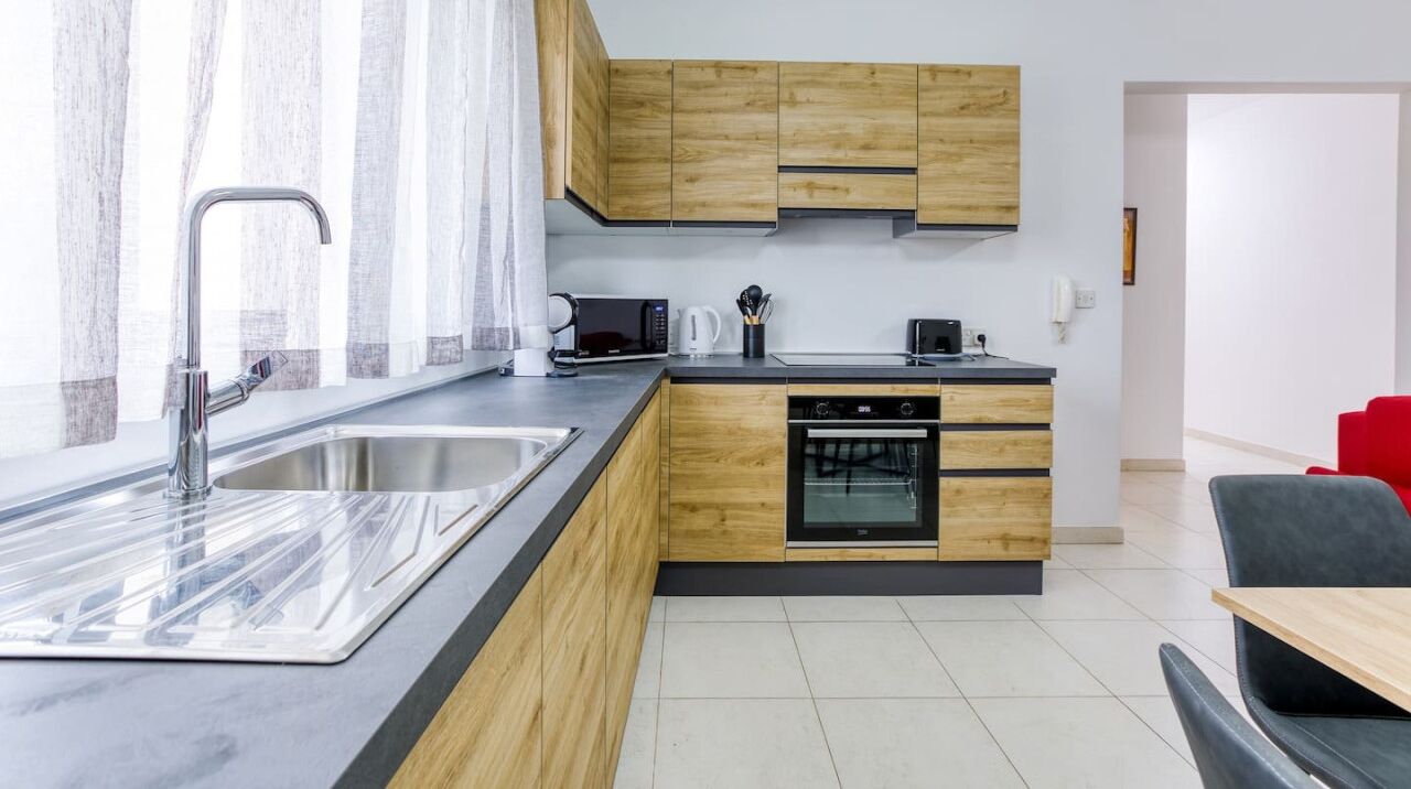 Eine moderne Küche mit Holzausstattung, einem Einbauofen und einer großen Spüle.