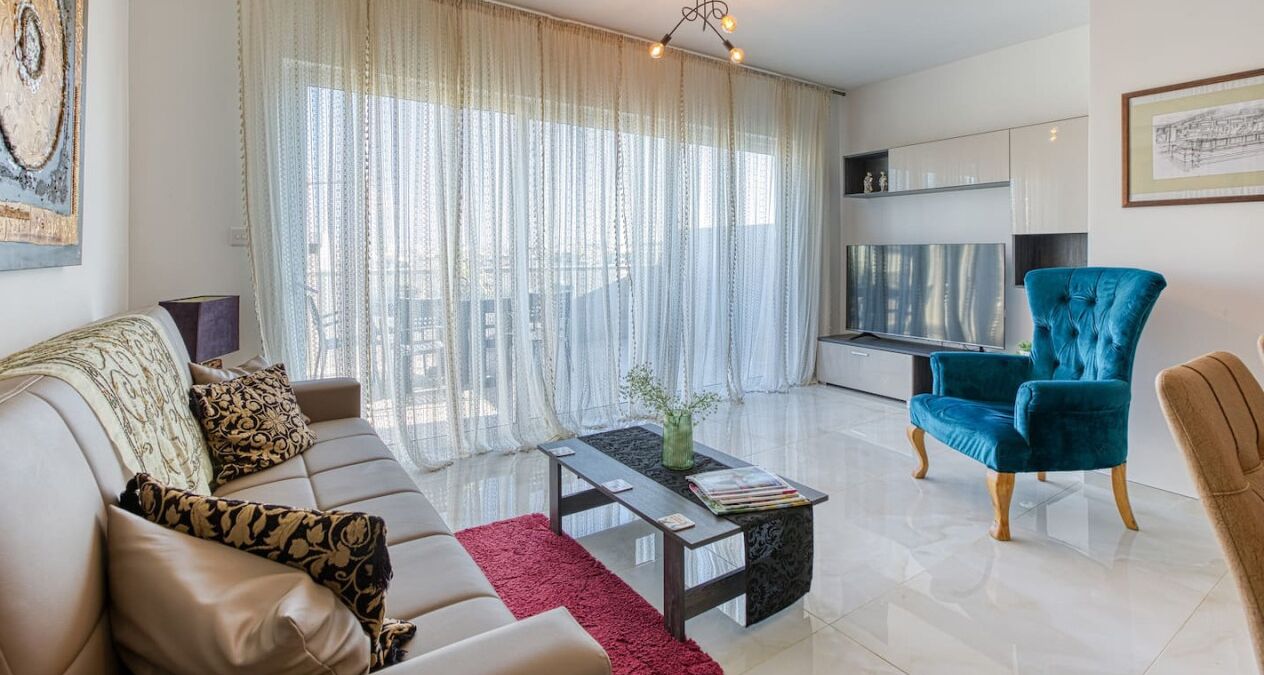 Una sala de estar moderna con un sofá, una mesa de centro y un sillón azul.