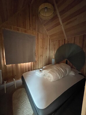 A wooden room with a bed, a wall-mounted TV, and a ceiling fan. - House 300 meters from the Rance River in a quiet location (La Richardais)