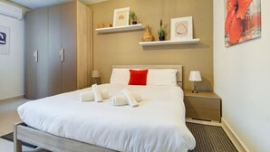 Une chambre d’hôtel comprenant un lit, des tables de chevet, une armoire et des étagères murales décoratives.