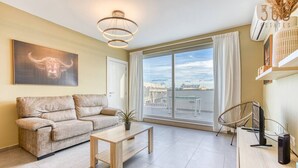 A modern living room with a sofa, a coffee table, a chair, and a large window with a city view. - One of a kind 5BR penthouse with terrace in Pieta (Tal-Pietà)