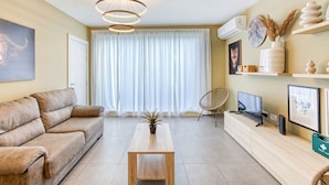 A modern living room with a sofa, a coffee table, a TV, and a bookshelf. - One of a kind 5BR penthouse with terrace in Pieta (Tal-Pietà)