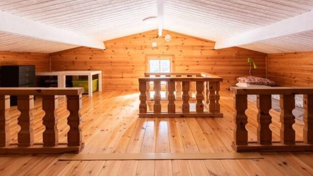 A spacious attic room with wooden walls and a sloped ceiling. - 6 Person Holiday Home in Bredaryd (Bredaryd)
