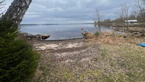 A lakeside view with a dock, trees, and a distant building. - 6 Person Holiday Home in Bredaryd (Bredaryd)