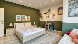 A bedroom with a bed, bedside tables, a desk, and a chair.