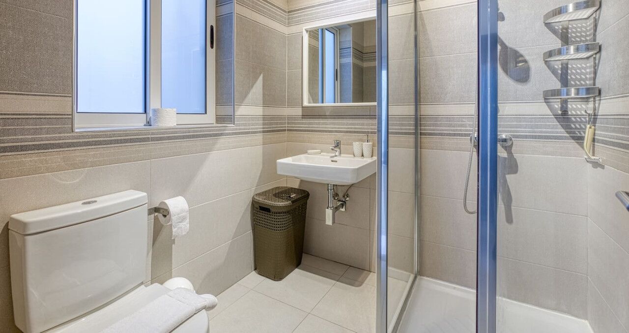 Une salle de bain avec des toilettes, un lavabo et une douche.