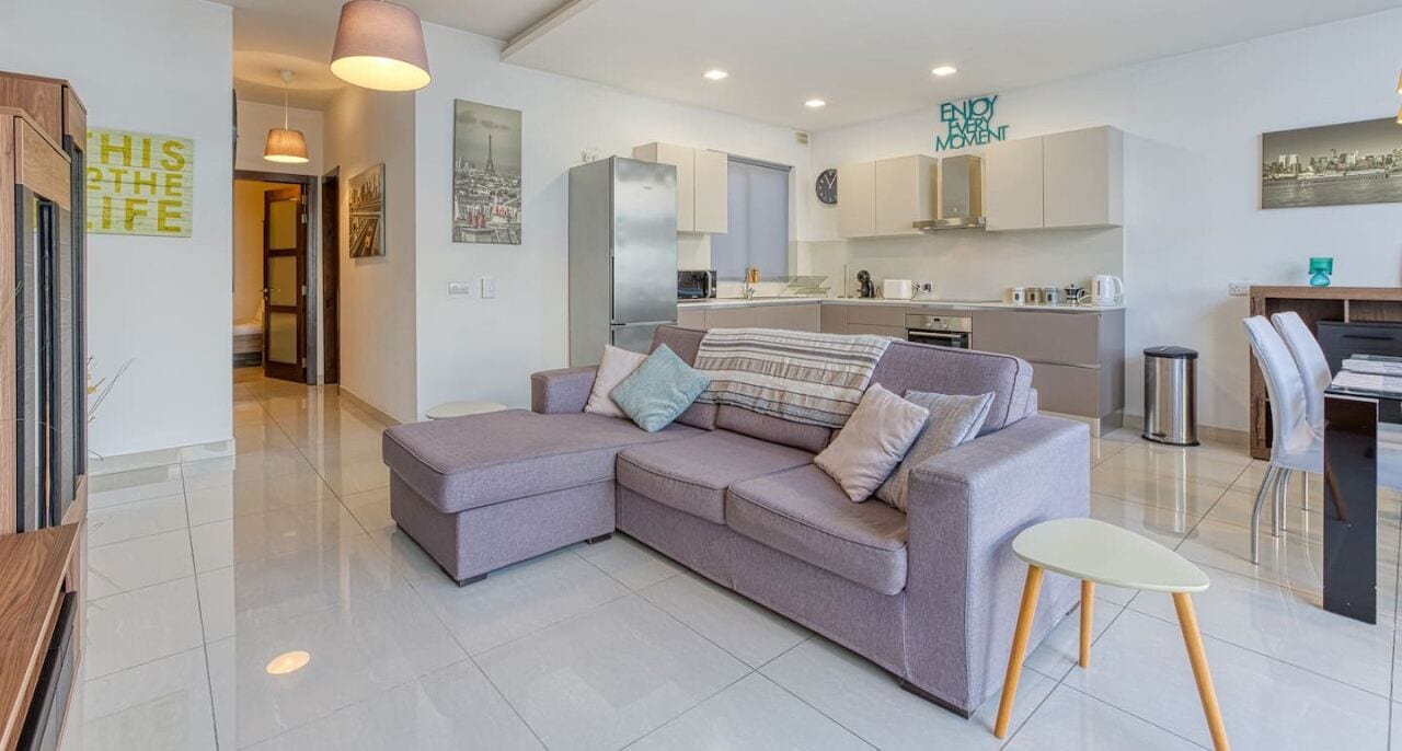 Una sala moderna con un sofá modular, un comedor y una cocina.